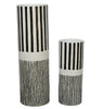 Two cylindrical vases with black and white striped patterns on a white background