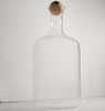 Clear glass carafe with wooden stopper on a white background
