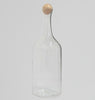 Clear glass bottle with wooden stopper on a light gray background