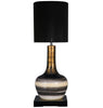 Decorative table lamp with a black shade and striped base on a white background