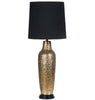 Decorative table lamp with gold base and black shade on a white background