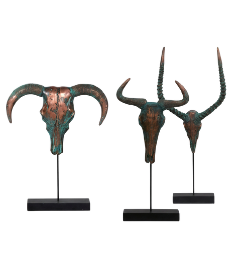 Three bronze animal head sculptures with large horns on black stands against a white background