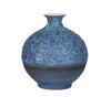A blue volcanic inspired vase with a rough lava like finish and gold accents, displayed against a white background.